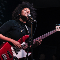 person playing electric bass guitar